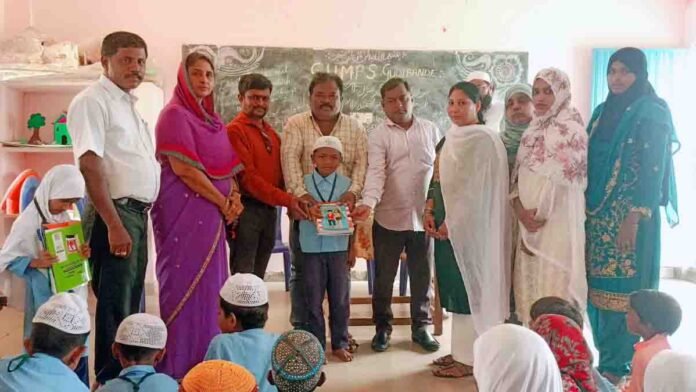 Students receiving educational materials at a Government Urdu School event in Gudibande, Karnataka, as Karnataka Urdu Academy President Mohammad Naseer addresses issues of declining admissions