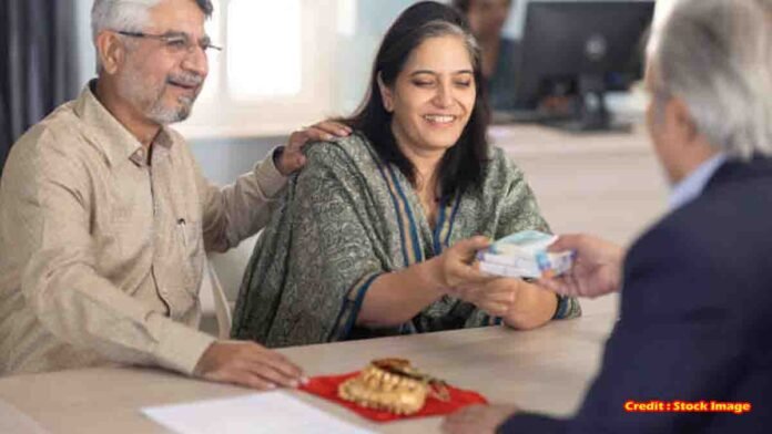 Gold Loan - Indian woman giving gold jewelry for loan at bank counter