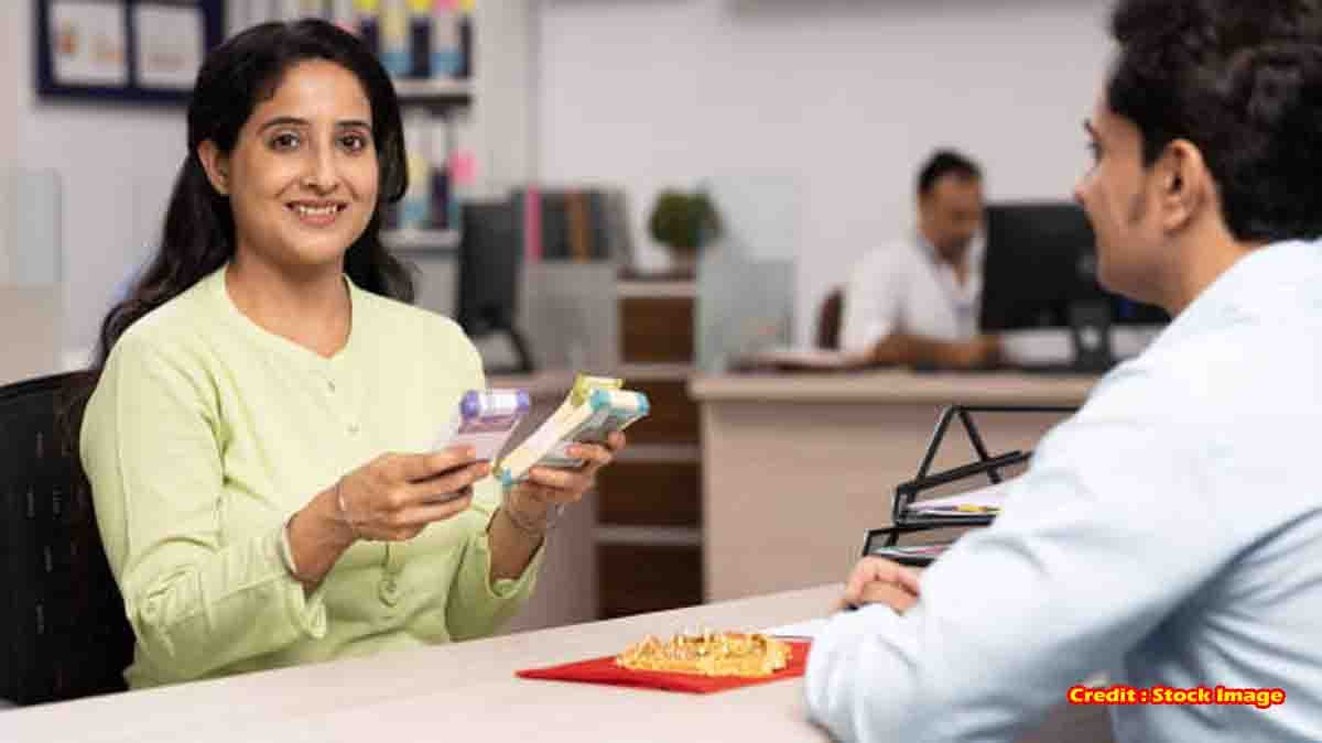 Gold Loan - Indian woman giving gold jewelry for loan at bank counter