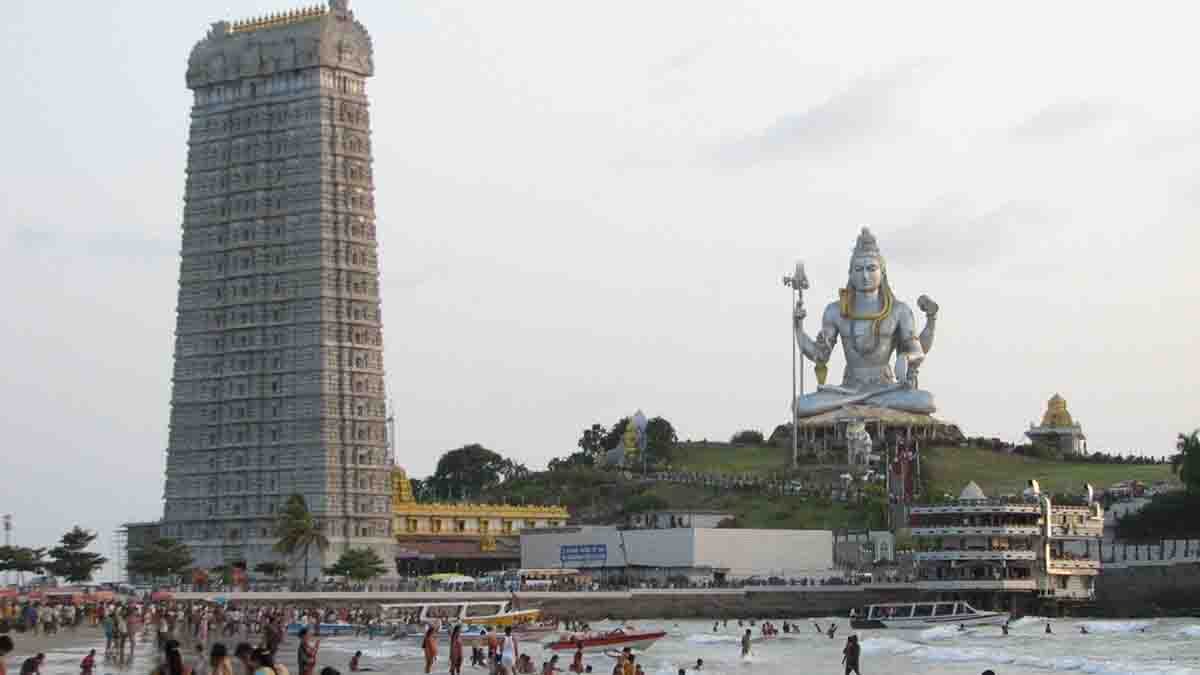 Devotees visiting Murudeshwar Temple in traditional attire with the giant Shiva statue in the background