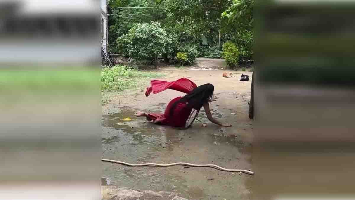 Indian girl in red saree slips while dancing in wet courtyard while making a viral Instagram Reels