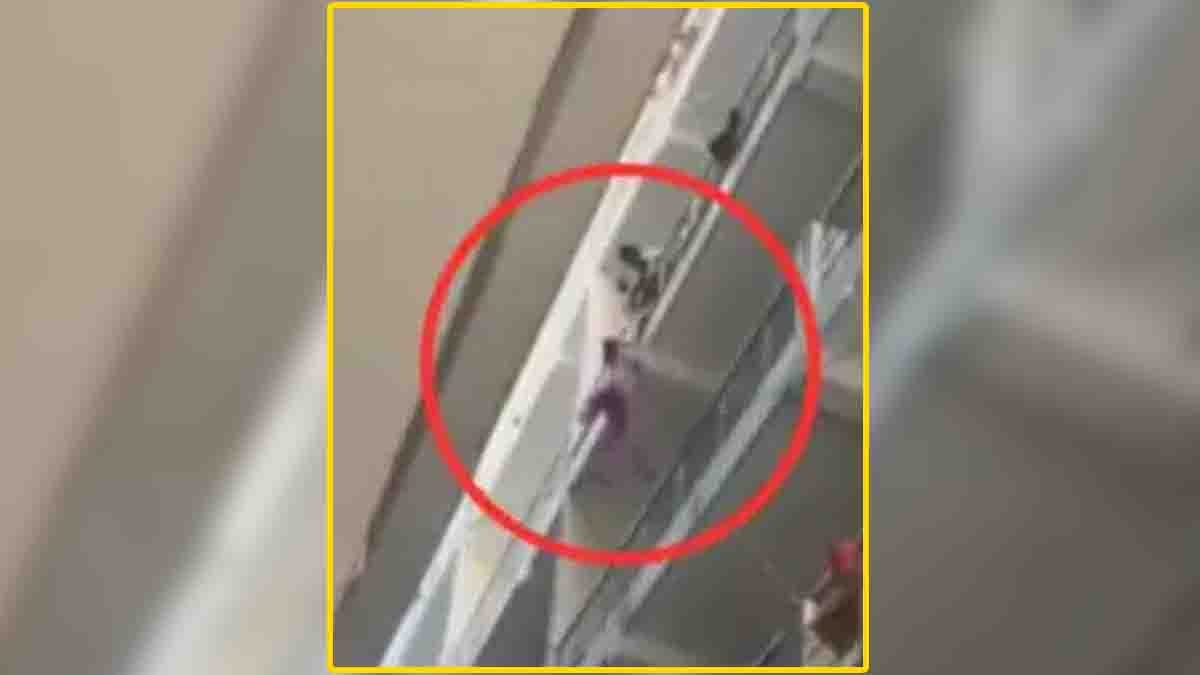 A woman hanging from a balcony railing in Rishikesh while others try to help - Viral video