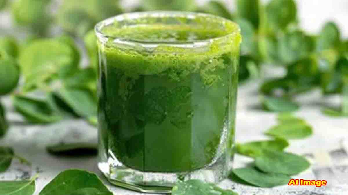 Glass of fresh moringa (drumstick leaves) water with raw leaves in the background