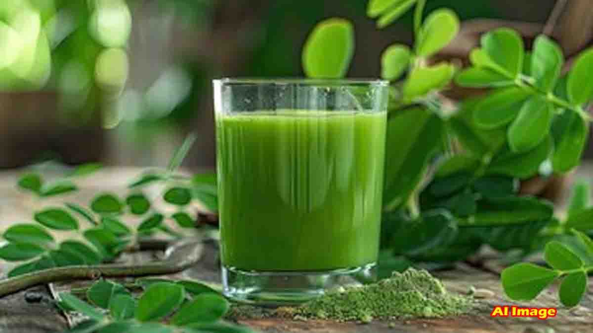 Glass of fresh moringa (drumstick leaves) water with raw leaves in the background