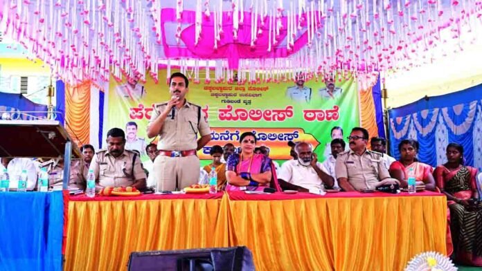 Mane mane police Event 0 Chikkaballapur police officers conducting home visits in Somenahalli village, interacting with villagers, promoting proactive policing and community safety, women and children engaged, realistic daylight setting