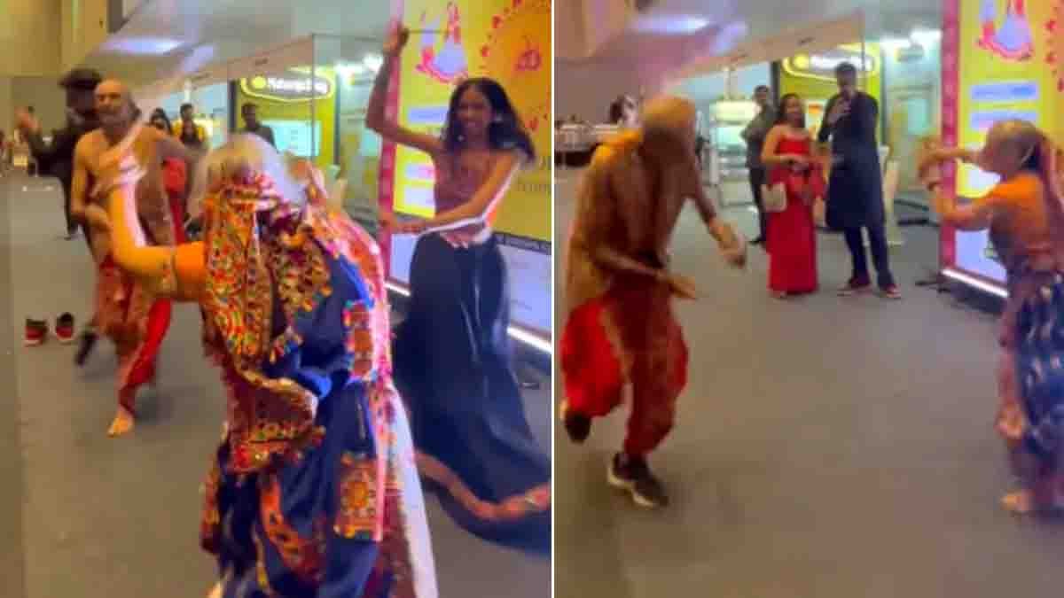 Elderly couple performing energetic Dandiya dance in colorful traditional Garba outfits during Navaratri 2025 celebration