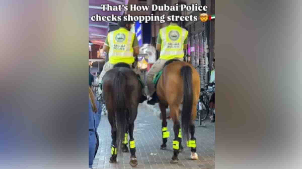 Dubai Police officers patrolling on horses through busy night market in Dubai