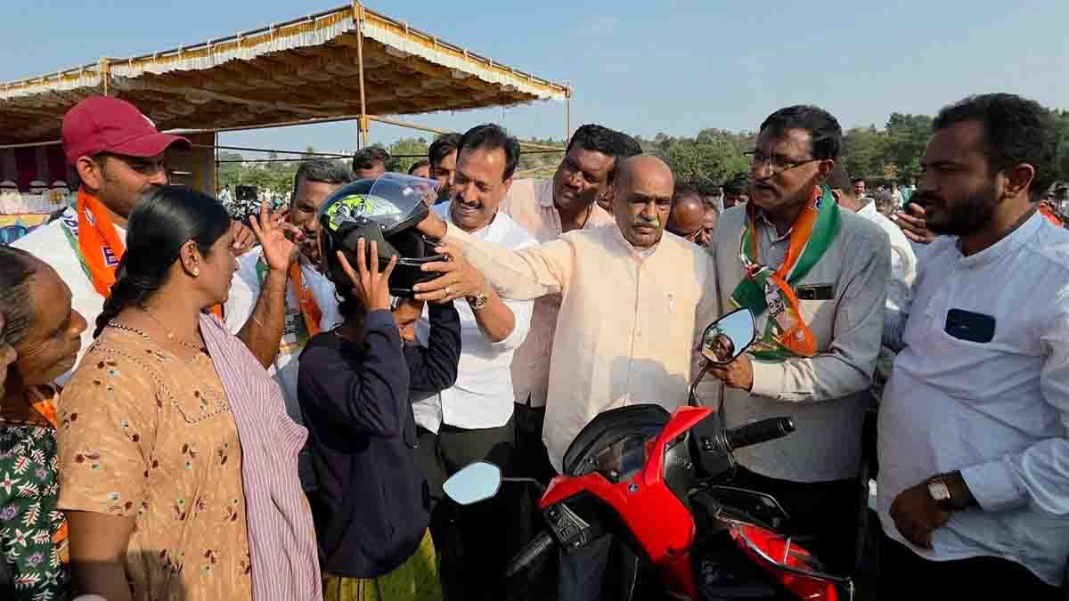 Social worker Harinath Reddy distributing free helmet to promote road safety in Gudibande taluk