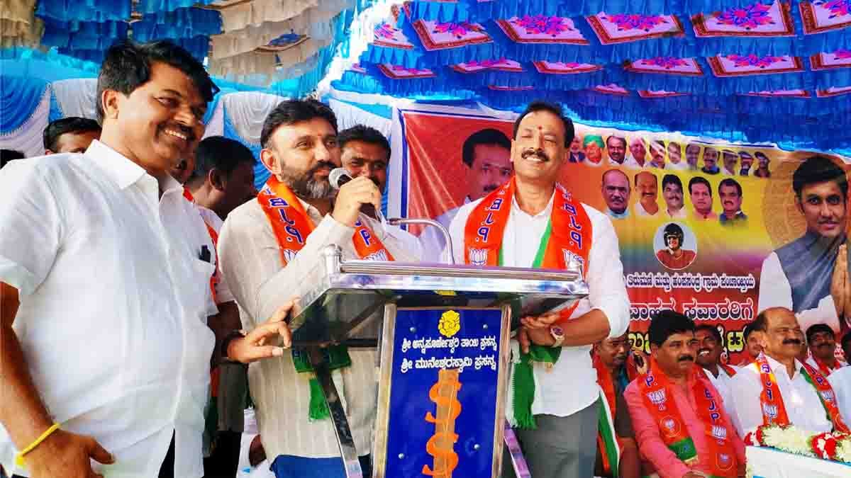 MP Sudhakar distributing free helmets to two-wheeler riders during a road safety awareness program in Gudibande, Chikkaballapur district