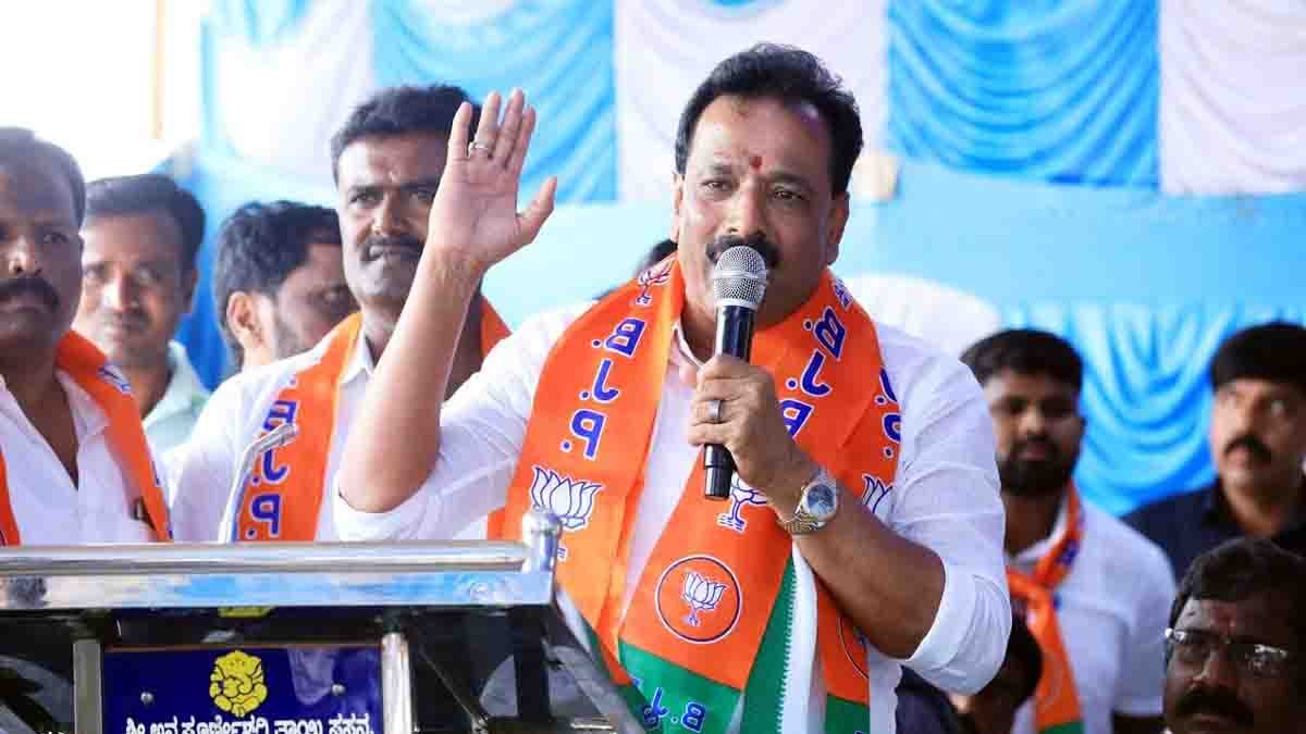 MP Sudhakar distributing free helmets to two-wheeler riders during a road safety awareness program in Gudibande, Chikkaballapur district