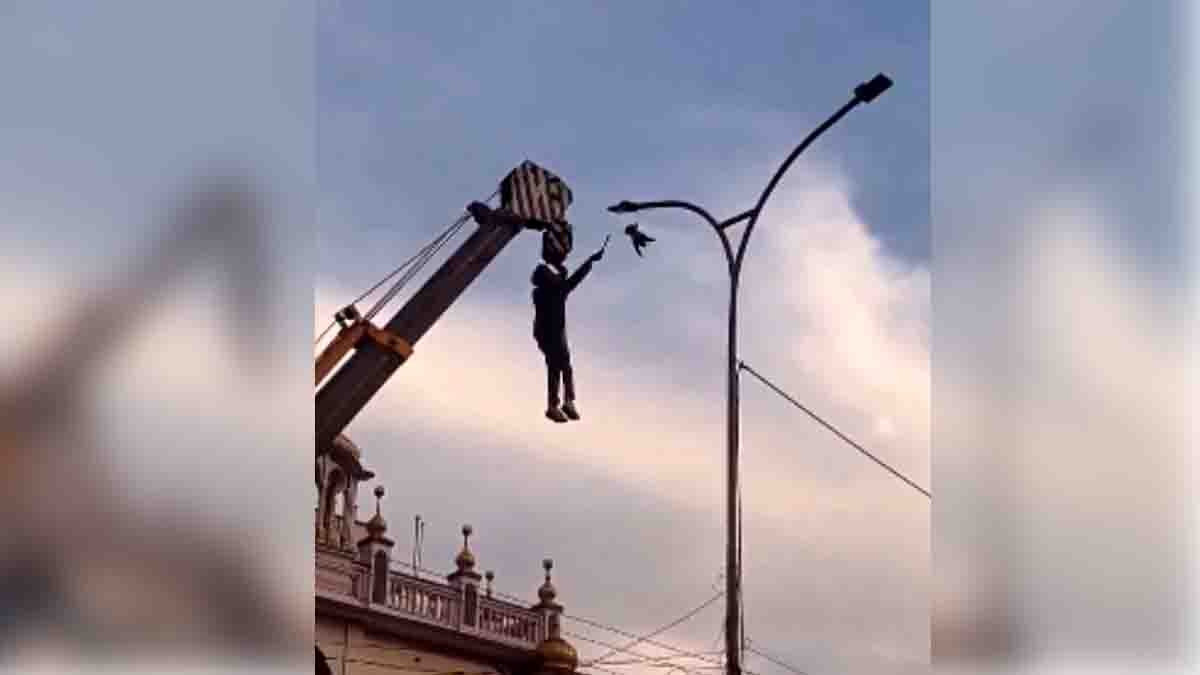 Punjab hero hanging from a crane to rescue a bird trapped in high-voltage electric wires near a gurdwara