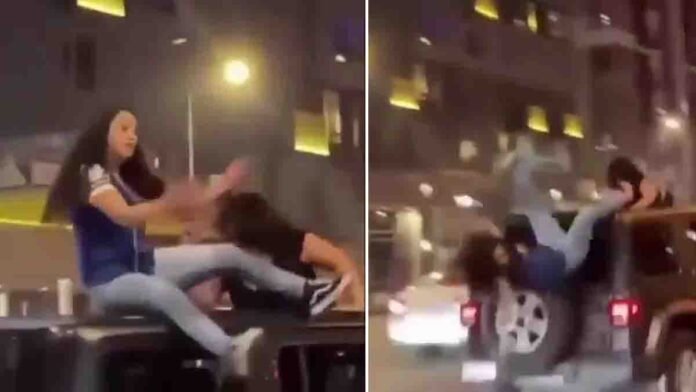 Dangerous car stunt performed by young women on a moving vehicle on public road