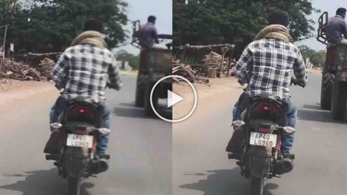 Young man performing a viral python bike stunt with a giant snake wrapped around his neck while riding a motorcycle