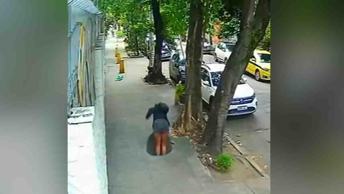 Woman Falls Manhole while using her smartphone in a viral CCTV video. The incident serves as a warning about distracted walking and road safety awareness.